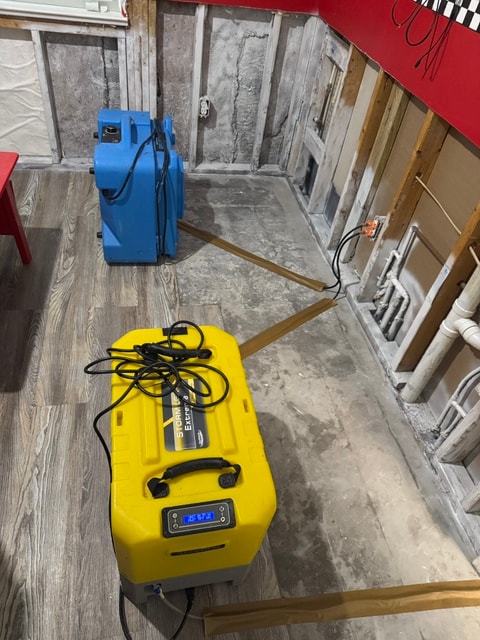 Restoration equipment — blue air mover and yellow dehumidifier